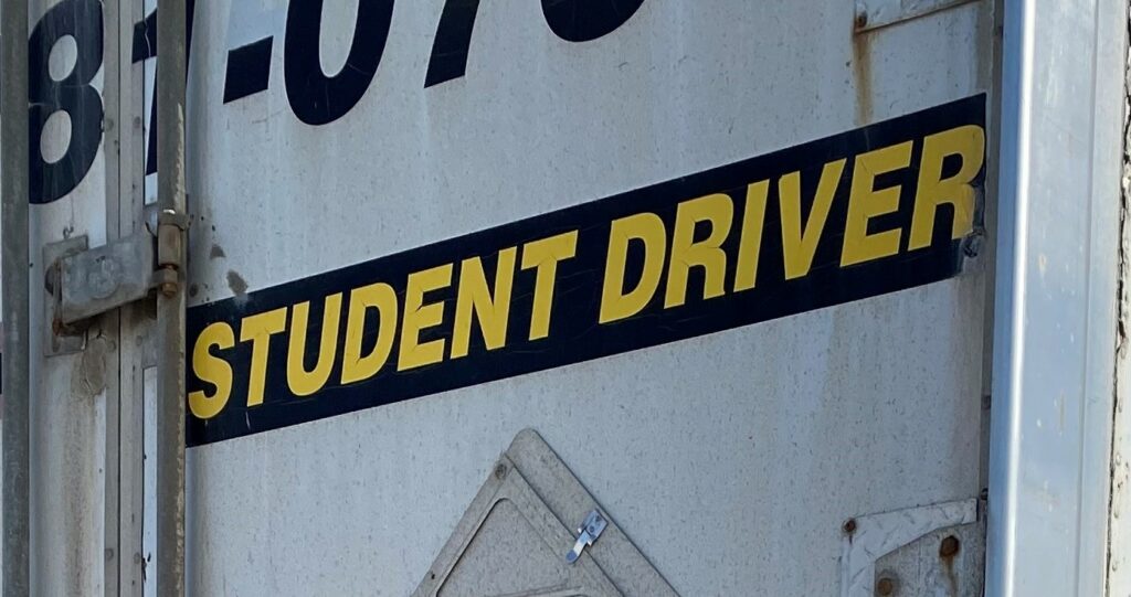 تصویر یک تریلر که دانشجو راننده روی آن نقاشی شده است